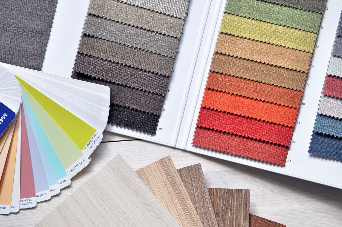 Colour swatches and paper samples stacked beside narrative notes